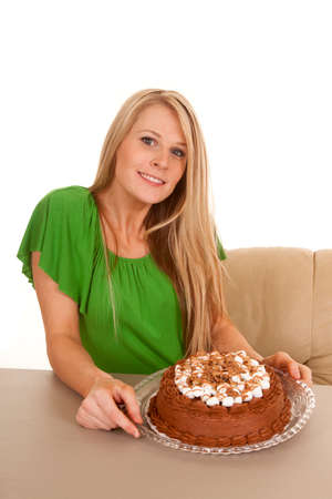 A woman with a smile on her face, holding on to her chocolate cake.の写真素材