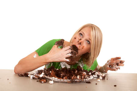 A woman shoving her face with cake .の写真素材
