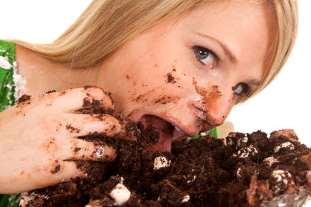 A close up of a woman shoving her face with chocolate cake.の写真素材