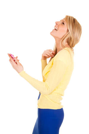 A woman holding on to her cell phone laughing.の写真素材