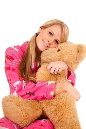 A woman hugging her teddy bear with a big smile on her face.の写真素材