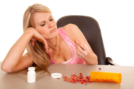 a woman with her head on her hand looking at a pillの写真素材