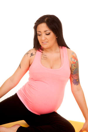a pregnant woman sitting on a fitness mat stretching.の写真素材