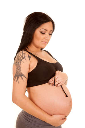 a pregnant woman looking down at her belly.の写真素材