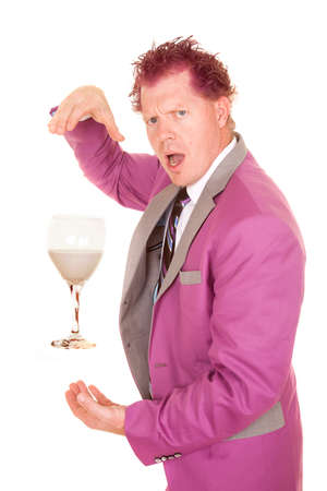 A man in  a purple suit with a shocked expression on his face, with a glass cup floating inbetween his hands.の写真素材