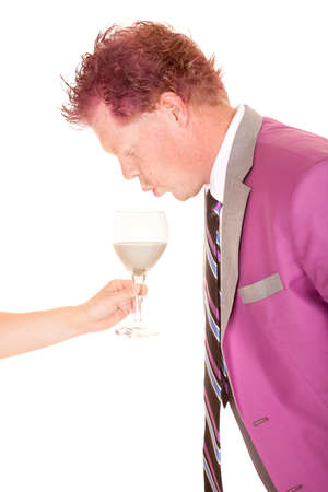 a man taking a drink with out any hands from a  person handing him a drinkの写真素材