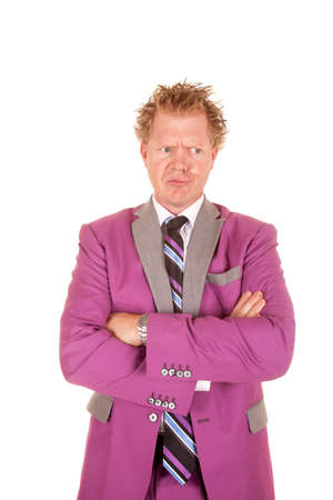 A man in a purple suit standing with a funny expression on his face.の写真素材