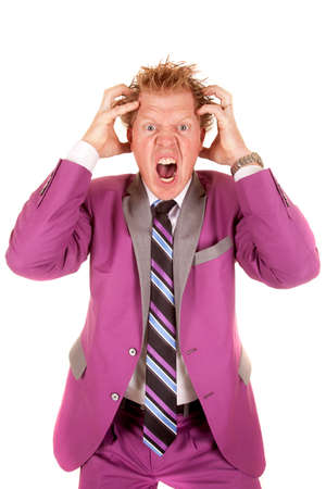 A man standing with his hands in his hair frustrated.の写真素材