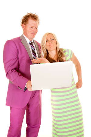 A man with a smile on his face holding on a computer and the woman has a funny expression.の写真素材