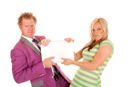 A business man and woman with angry expressions fighting over a laptopの写真素材