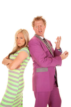 A man and woman standing back to back with unhappy expressions on their faces.の写真素材