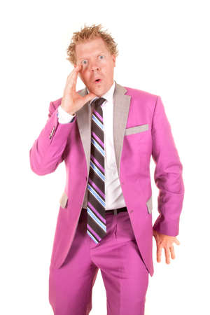 A man in a purple suit with his hand by his mouth yelling.の写真素材