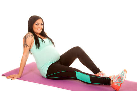 a pregnant woman leaning back on her workout mat.の写真素材