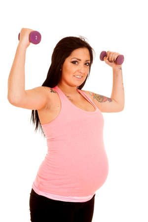 a woman flexing her arms using weights to work out.の写真素材