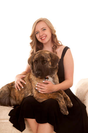 A woman with a smile having her dog lay on her lap.の写真素材