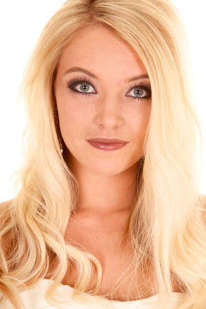 A close up of a blond woman with a small smile on her face.の写真素材
