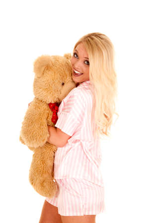A woman in her pajamas holding on tight to her teddy bear.の写真素材