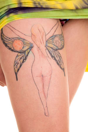 A close up of a woman's leg showing her fairy tattoo on her thigh.の写真素材