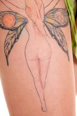 a close up of a woman's leg with a fairy tattoo on her leg.の写真素材