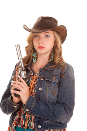 a woman in her denim jacket holding onto her pistolの写真素材