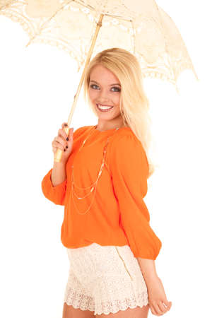 A woman with a smile on her face holding on to a lace umbrella.の写真素材