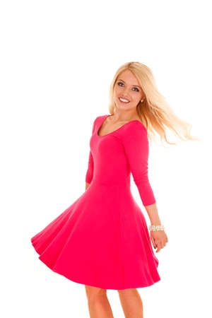 A woman in her pink dress spinning around in a circle.の写真素材