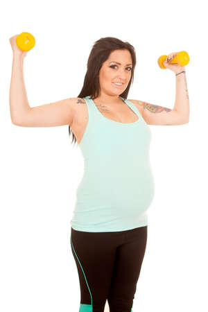 A woman with a smile on her face using weights to work out.の写真素材