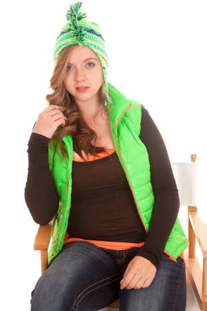 a woman sitting in a chair in her winter clothing,の写真素材