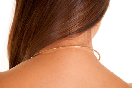 A close up of the back of a woman's neck wearing a necklace.の写真素材