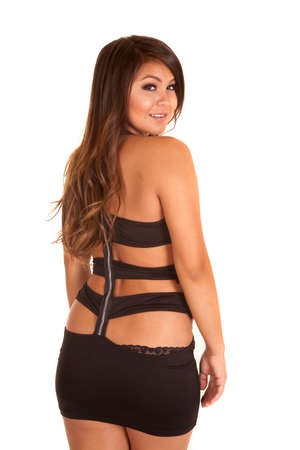 A woman showing off the back of her dress, looking over her shoulder.の写真素材