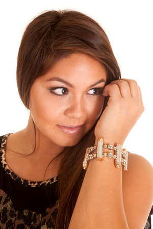 A close up of a woman with her hand by her face, wearing a bullet bracelet.の写真素材