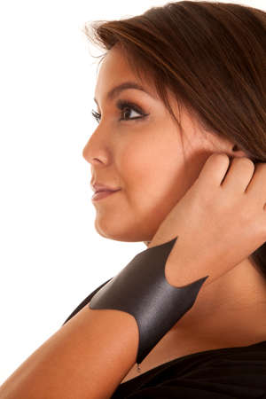 A side view of a woman with her arm up and a leather bracelet on her wrist.の写真素材