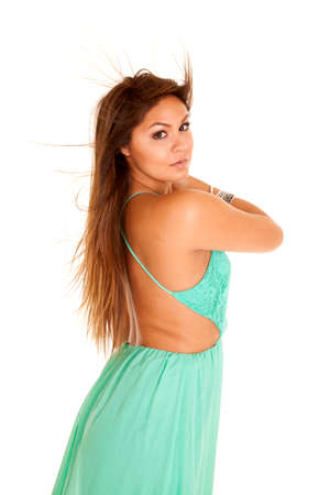 a close up side view of a woman with her hair blowing in the wind, wearing a teal dress.の写真素材