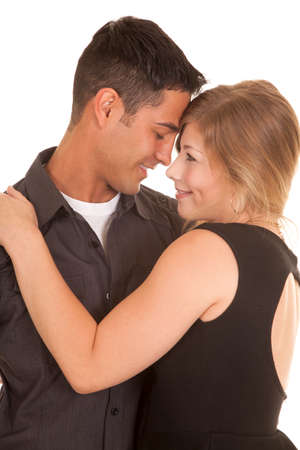 A man and woman cuddling close together with smiles on their lips.の写真素材