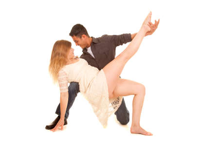 a couple dancing and doing a pose. He is holding her leg up.の写真素材