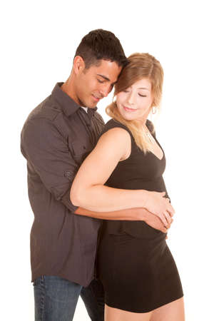 A man with his arms around his woman with a small smile on both of their lips.の写真素材