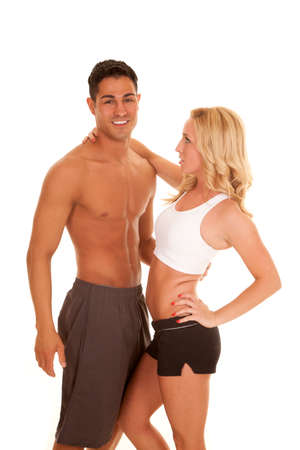 A couple in their fitness clothing showing off their fit bodies, holding on to each other.の写真素材