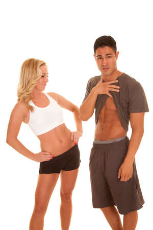 A woman looking down at a man's fit abs in their fitness clothing.の写真素材