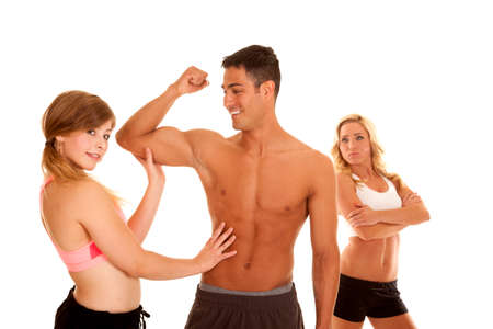 A woman feeling his mans muscles while the women in the background is jealous.の写真素材