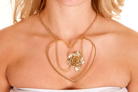A close up of a woman wearing a heart and rose necklace.の写真素材