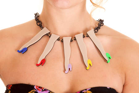 A woman wearing a necklace that has colorful leg charms hanging from it.の写真素材