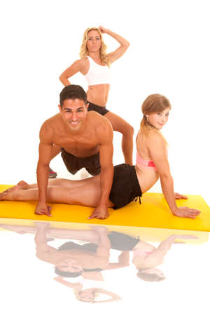 Two women and a man doing different exercises at once.の写真素材