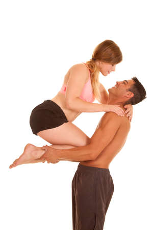 a man in his fitness clothes holding up his woman on his arms.の写真素材