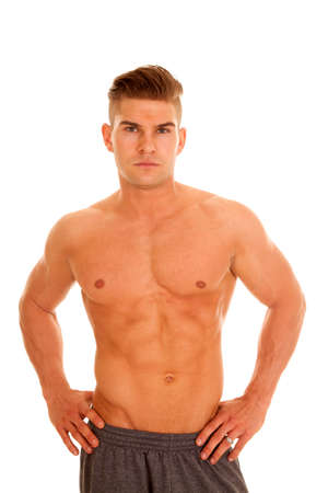a man with his hands on his hips without a shirt on with a serious expressionの写真素材
