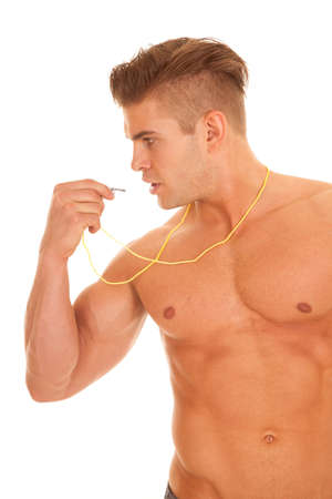 A man with no shirt on getting ready to blow his whistleの写真素材