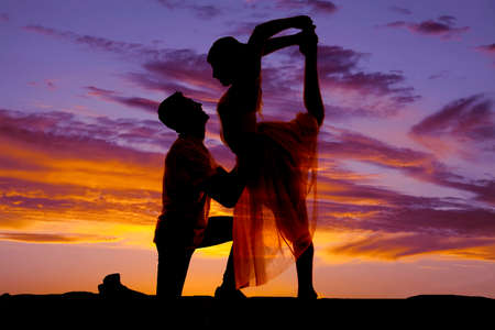 A silhouette of a man and woman doing dance poses in the outdoors.の写真素材