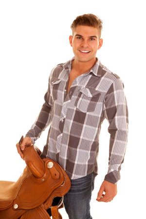 A cowboy holding onto his  sadde with a serious expression.の写真素材