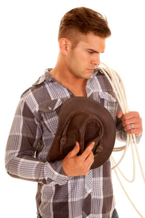 a man looking down with his hat by his chest holding on to his ropeの写真素材