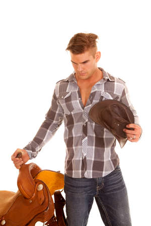 A cowboy holding onto his  sadde with a serious expression.の写真素材