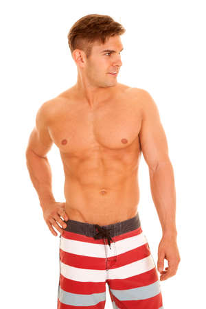 a man looking to the side wearing his red and white swim shorts.の写真素材